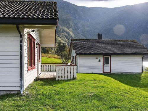 ein kleines weißes Gebäude mit einer Veranda und einem Haus in der Unterkunft 7 person holiday home in Selje in Selje
