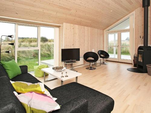 a living room with a couch and a tv at 6 person holiday home in Hirtshals-By Traum in Hirtshals