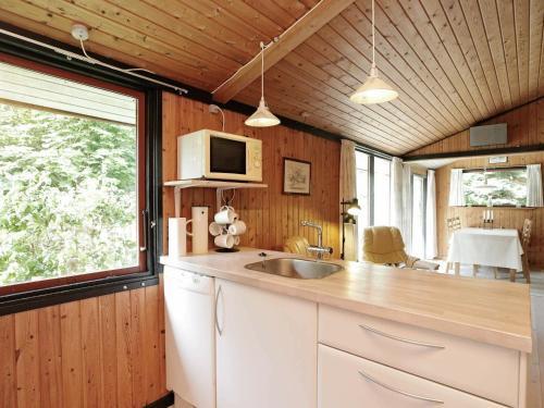 a kitchen with a sink and a microwave at 6 person holiday home in L s in Læsø