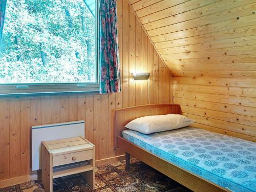 Vester SømarkenにあるHoliday home Aakirkeby Vの木造キャビン内のベッド1台が備わるベッドルーム1室を利用します。