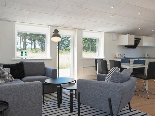 un salon avec des canapés et une table ainsi qu'une cuisine dans l'établissement 6 person holiday home in L kken, à Løkken