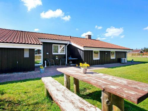 a wooden picnic table in front of a house at 10 person holiday home in Løkken-By Traum in Løkken