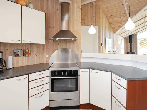 a kitchen with white cabinets and a stove top oven at 7 person holiday home in Thisted in Nørre Vorupør