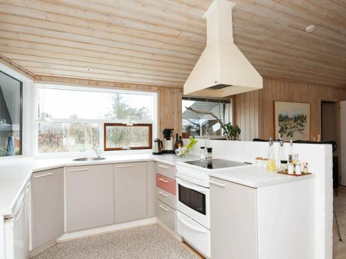 ヒュールスミンネにある6 person holiday home in Juelsmindeの木製の天井、白い家電製品付きのキッチン