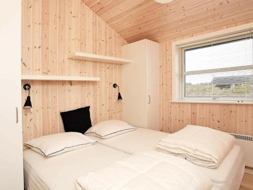zwei Betten in einem Zimmer mit Holzwänden in der Unterkunft 6 person holiday home in Hirtshals-By Traum in Hirtshals