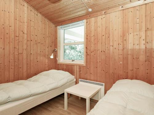 two beds in a room with wooden walls and a window at Nature Retreat in albaek - By Traum Ferienwohnungen in Jerup