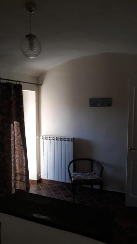 a dark room with a chair and a window at Agriturismo Cascina Binelli in Dogliani