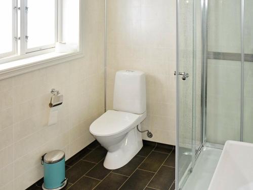 a bathroom with a toilet and a glass shower at 8 person holiday home in averøy in Henda