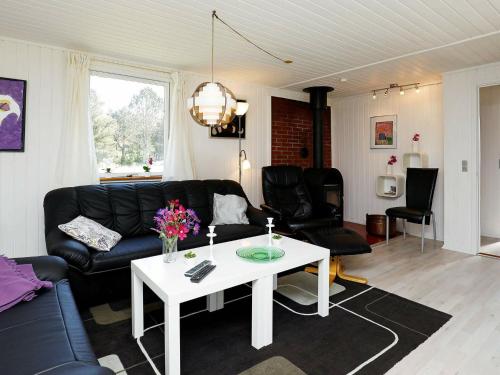 sala de estar con sofá negro y mesa blanca en 5 person holiday home in Vejers Strand, en Vejers Strand