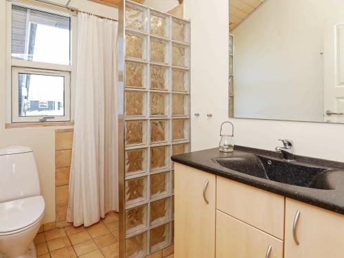 a bathroom with a sink and a toilet and a mirror at 9 person holiday home in Hirtshals-By Traum in Hirtshals