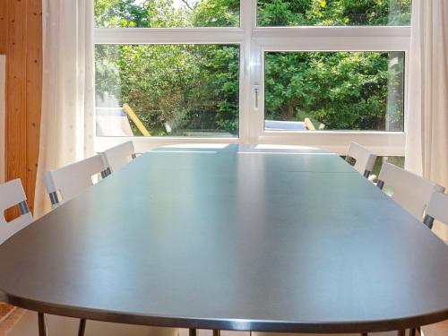 Hadsundにある6 person holiday home in Hadsundの大きなテーブルと椅子(窓2つ付)