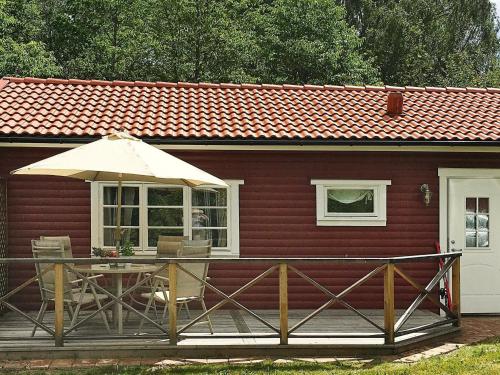 Kyrkhultにある4 person holiday home in KYRKHULTの木製デッキ(テーブル、傘付)