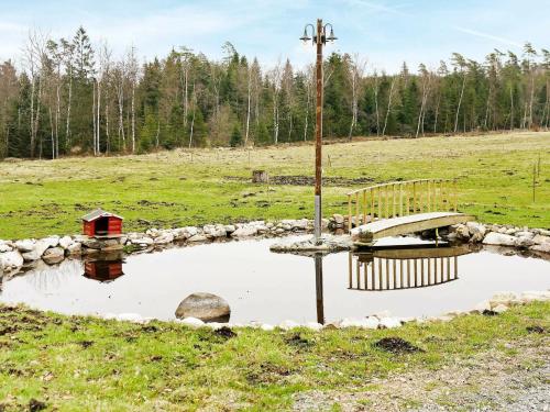 Åsljungaにある4 person holiday home in sljungaの鳥居と畑十字架のある池