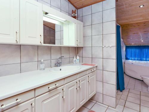 y baño con lavabo, aseo y espejo. en 6 person holiday home in Bindslev, en Bindslev