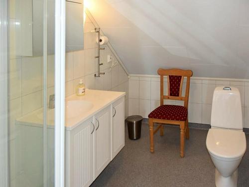 a bathroom with a sink and a toilet and a chair at Apartment Onarheim II in Onarheim