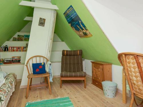 a room with a green ceiling with a chair and a couch at 7 person holiday home in Bredebro-By Traum in Ballum