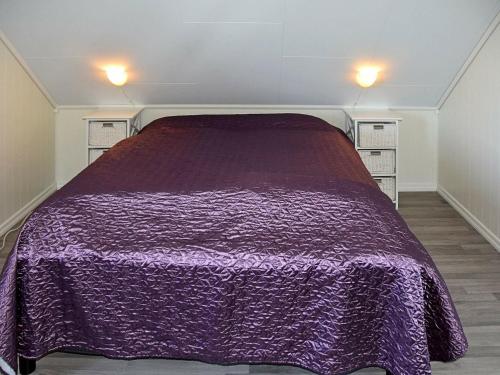 a bedroom with a purple blanket on a bed at 6 person holiday home in Onarheim in Onarheim