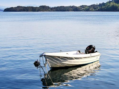 a small white boat sitting on a large body of water at 6 person holiday home in Onarheim in Onarheim