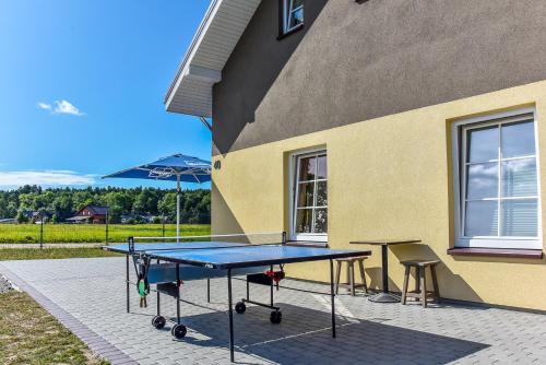 a ping pong table in front of a building at Karkle Beach Suites in Karklė