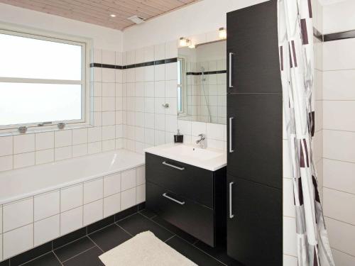 y baño con bañera blanca, lavamanos y bañera. en 6 person holiday home in Karreb ksminde, en Karrebæksminde