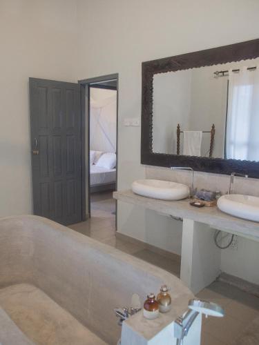 a bathroom with two sinks and a large mirror at Secret Garden Galle Fort in Galle