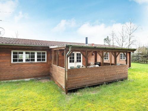 ein Haus mit einer Terrasse auf einem Hof in der Unterkunft 6 person holiday home in F rvang in Fårvang