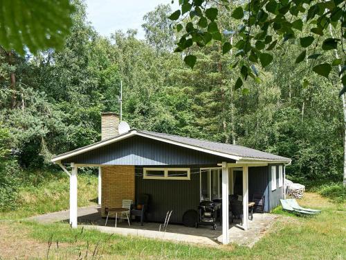 a small house with a patio in a field at 5 person holiday home in Aakirkeby in Vester Sømarken