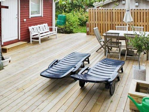 eine Terrasse mit einer Bank, einem Tisch, einem Tisch und Stühlen in der Unterkunft 5 person holiday home in DYR N in Stora Dyrön