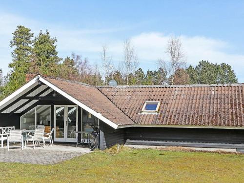 a house with a roof with a table and chairs at 6 person holiday home in R dby in Rødby