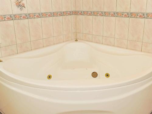 a white bath tub in a tiled bathroom at 8 person holiday home in Oksb l in Øster Vrøgum