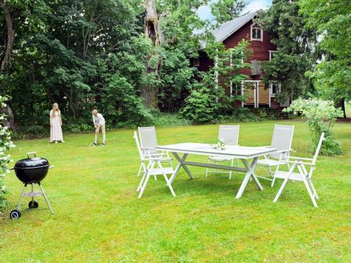 einen Grill und einen Tisch und Stühle im Hof in der Unterkunft 11 person holiday home in STORA SUNDBY in Böcklinge