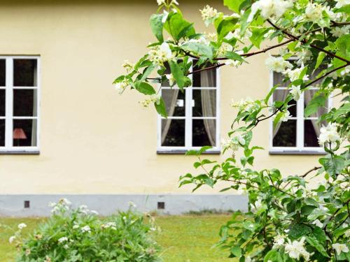 zwei Fenster auf einem Haus mit weißen Blumen im Gras in der Unterkunft 11 person holiday home in STORA SUNDBY in Böcklinge