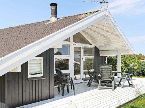 ein Haus mit Stühlen und einem Tisch auf einer Terrasse in der Unterkunft 6 person holiday home in Ebberup in Helnæs By