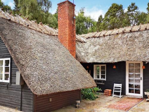Cette maison ancienne dispose d'un toit de chaume et d'une fenêtre. dans l'établissement 6 person holiday home in R dby, à Rødby