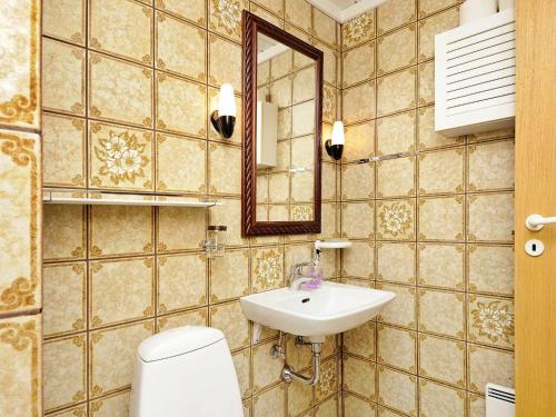 uma casa de banho com um WC, um lavatório e um espelho. em Three-Bedroom Holiday home in Henne 9 em Henne Strand
