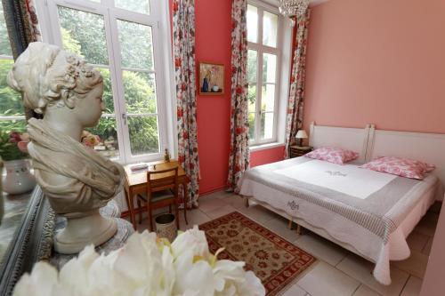 a bedroom with a statue of a girl in it at Maison D'Hôtes Du Théâtre in Douai