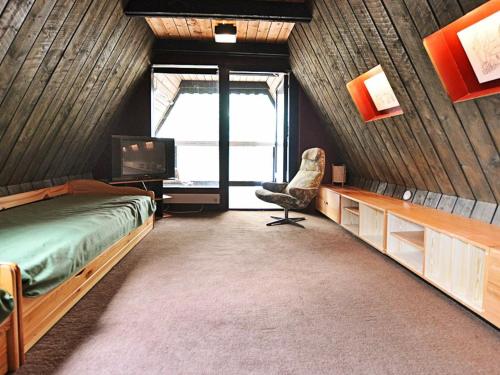 ÅsljungaにあるThree-Bedroom Holiday home in Örkeljunga 1のベッドルーム(ベッド1台、椅子、テレビ付)