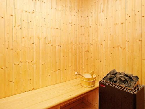a corner of a room with a wooden wall with a shelf with a toolbox at 10 person holiday home in Brovst in Brovst