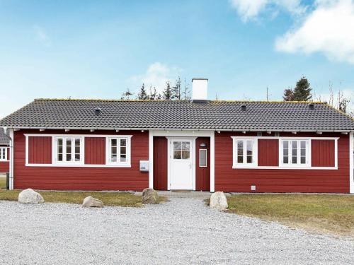 een rood huis met rotsen ervoor bij 8 person holiday home in Aabenraa in Danland Løjt