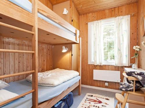 DannemareにあるHoliday Home Filosofstrædeの木製の部屋に二段ベッド付きのベッドルームがあります。