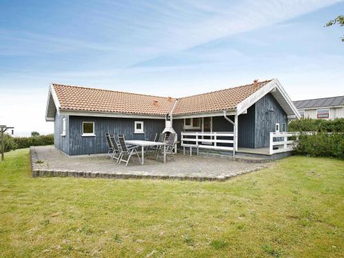 una casa azul con una mesa y sillas en un patio en 10 person holiday home in Hadsund, en Odde