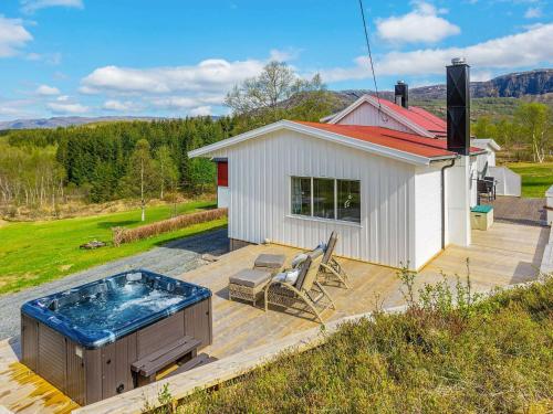 una bañera de hidromasaje en una terraza junto a una casa en 8 person holiday home in Inndyr, en Inndyr