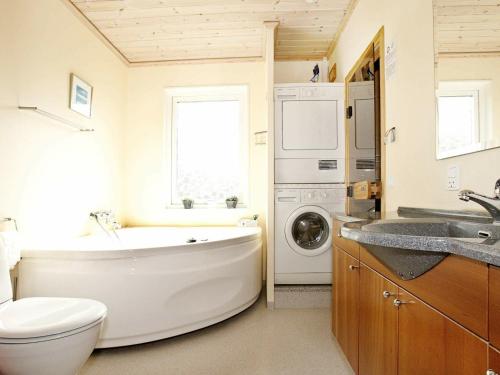 VestervigにあるHoliday Home Ingersvej IIIのバスルーム(バスタブ、シンク、洗濯機付)
