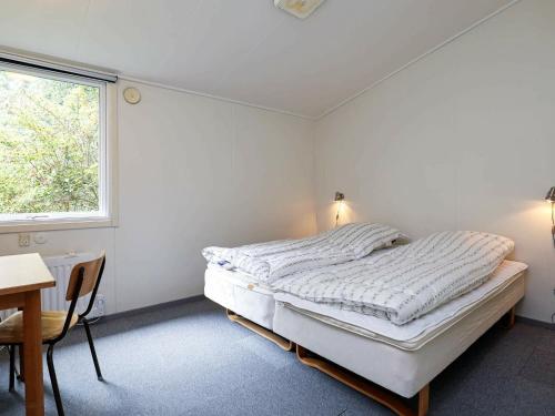 a bedroom with a bed and a desk and a window at Ten-Bedroom Holiday home in Øster Assels in Sillerslev