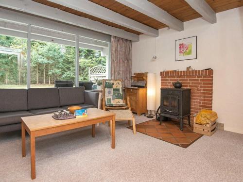 a living room with a couch and a wood stove at 5 person holiday home in Ebeltoft in Øksenmølle