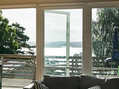 a living room with a couch and a large window at 4 person holiday home in H viksn s in Höviksnäs