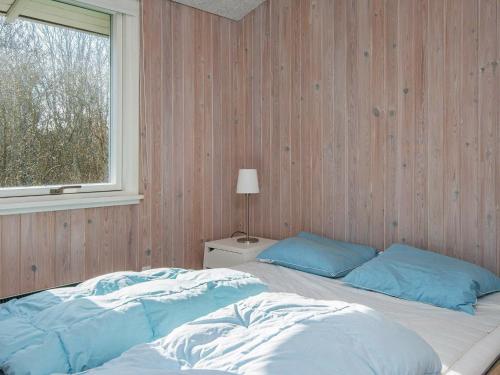 um quarto com uma cama com almofadas azuis e uma janela em Five-Bedroom Holiday home in Børkop 2 em Egeskov