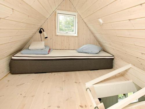 a small room with a bed in a tiny house at Holiday home in Skagen 4 in Skagen