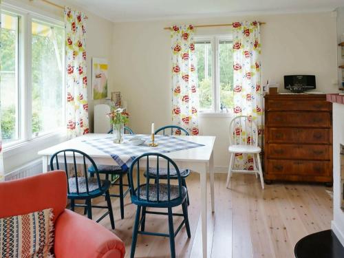 cocina con mesa, sillas y ventanas en Holiday home BORÅS en Borås