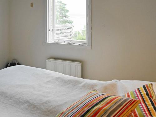 a bedroom with a white bed and a window at 4 person holiday home in H viksn s in Höviksnäs